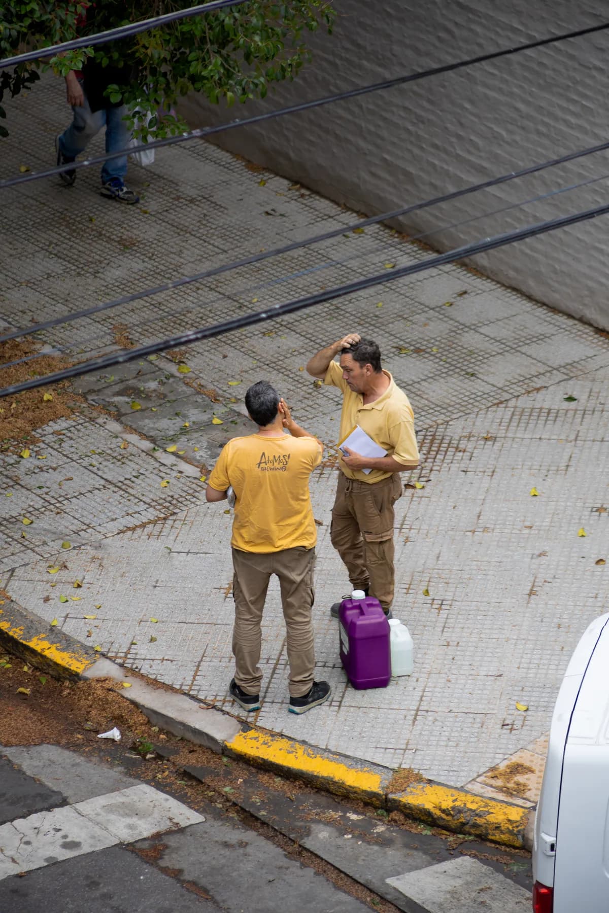 Two workers with complementary-colored outfit and chemical jug