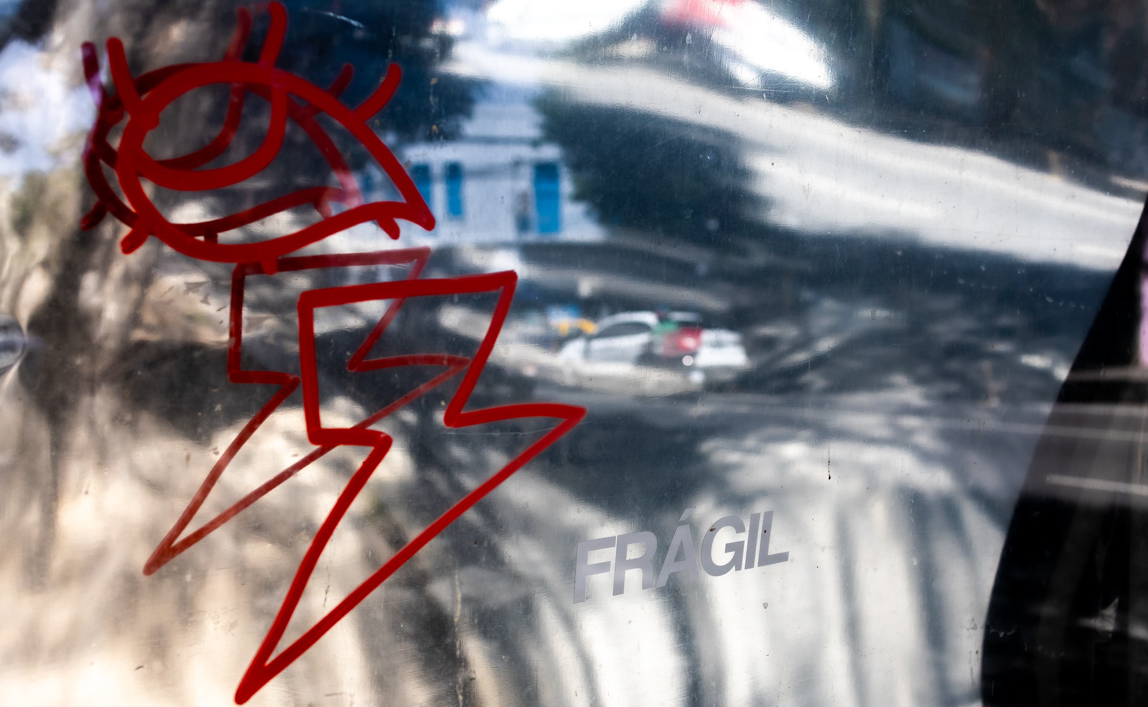 Bent ad panel with a graffiti tag reflecting a street