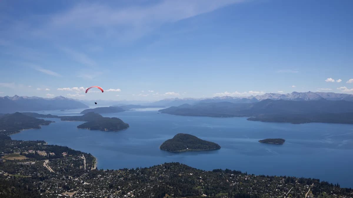 Paragliders flying over Bariloche with huge lake Nahuel Huapi in the background