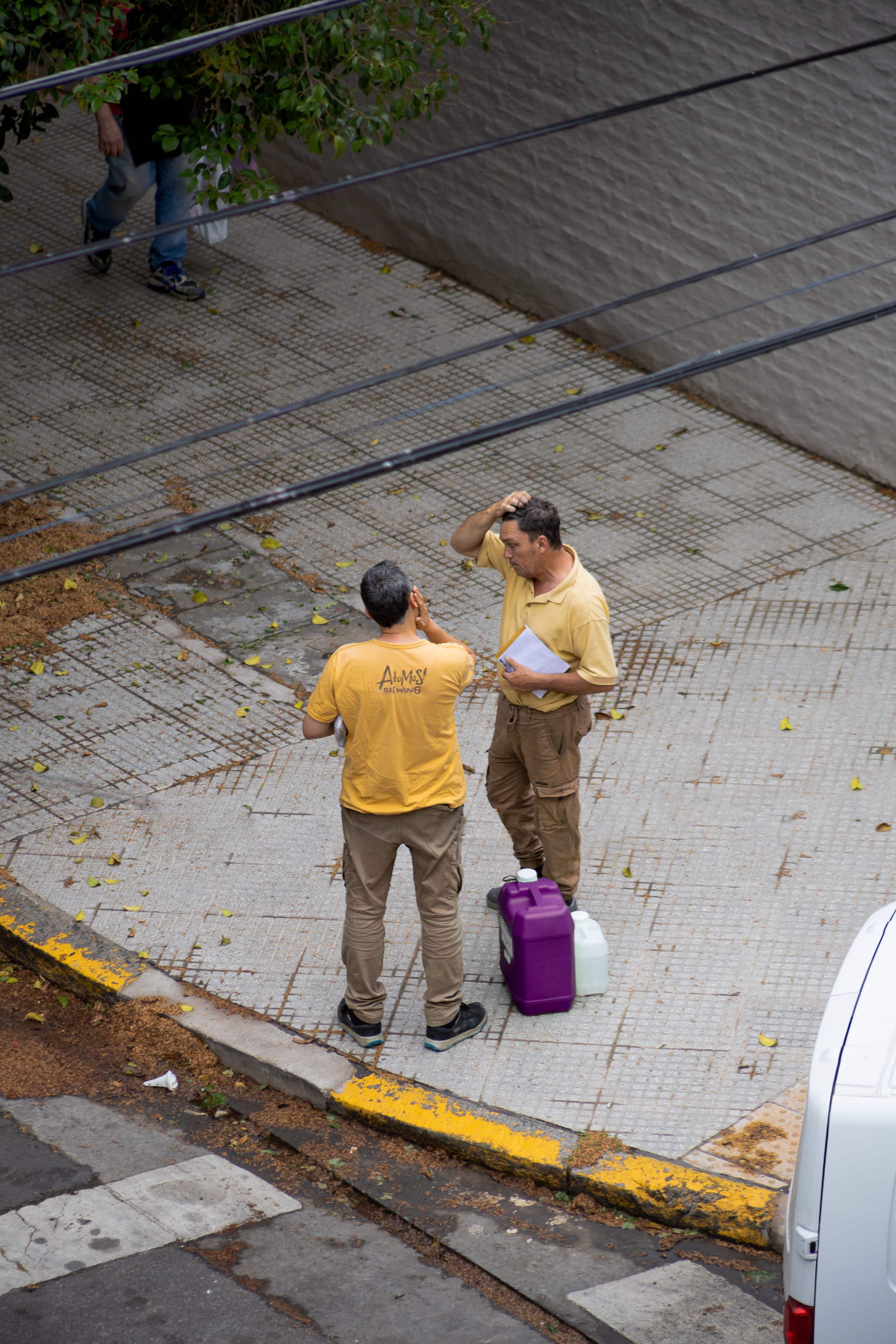 Two workers with complementary-colored outfit and chemical jug