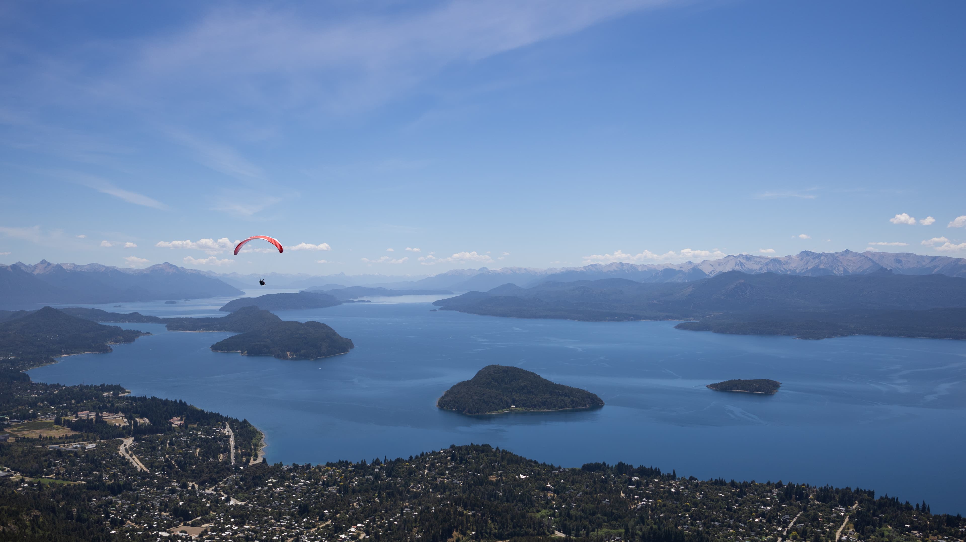 Paragliders flying over Bariloche with huge lake Nahuel Huapi in the background